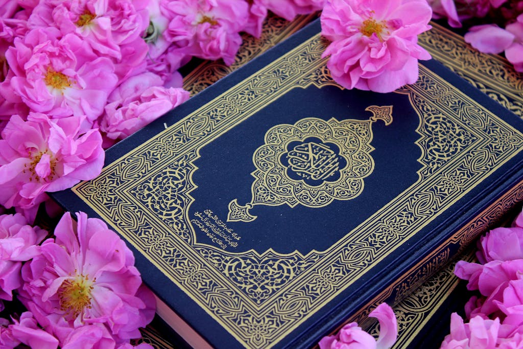 A Quran placed amidst vibrant pink flowers, symbolizing peace and faith.